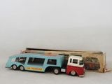 un petit bus et un petit camion devant une boîte