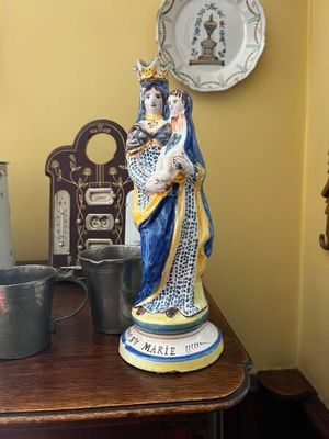 une statue de femme tenant un bébé sur une table