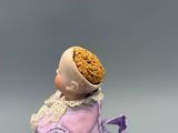 a figurine of a woman with a hat on top of her head