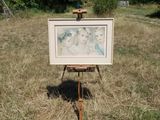 a picture of a painting on a easel in a field