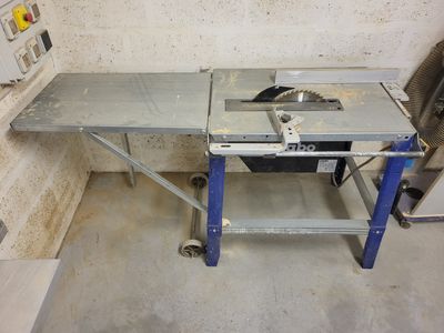 une table sur laquelle est posée une scie, dans une pièce