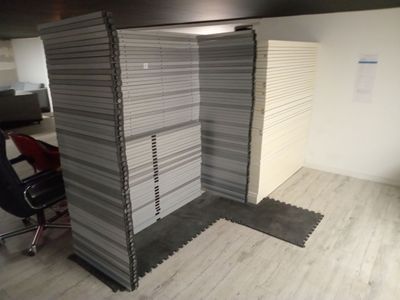une image représentant un box de bureau avec un bureau et une chaise