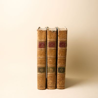 deux vieux livres posés l'un sur l'autre sur une surface blanche