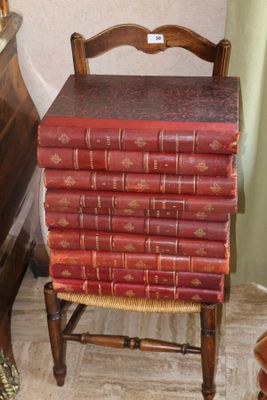 une pile de livres posée sur une chaise à côté d'une commode