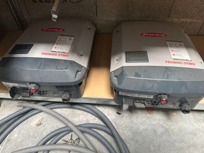 deux onduleurs solaires posés sur une étagère dans un garage