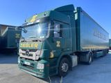 un camion vert garé sur un parking