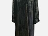 a black fur coat on a mannequin stand against a white background