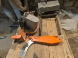 an orange tool sitting on a pallet next to a pair of scissors