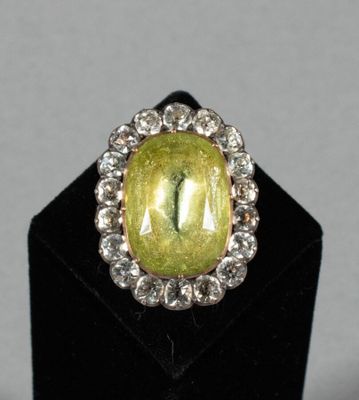 a close up of a ring with a yellow stone surrounded by diamonds