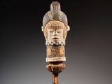 une tête d'homme sculptée posée sur un socle en bois