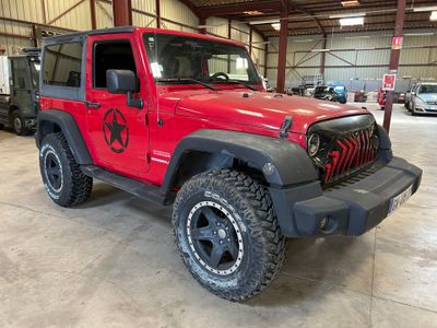 une photo d'une jeep rouge garée dans un garage