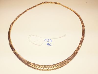 a close up of a gold necklace on a table with a price tag
