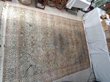 un grand tapis posé à même le sol dans une pièce où se trouvent de nombreuses chaises