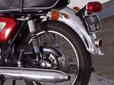 a red motorcycle parked in a garage with a white wall