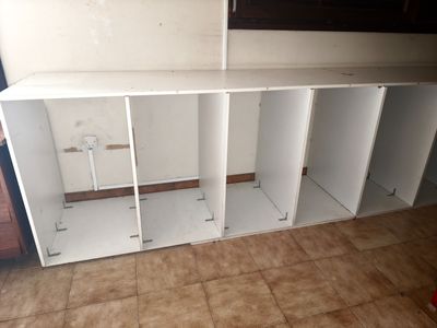 a room with a shelf and cabinets in it