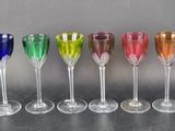 six wine glasses are lined up in a row on a table