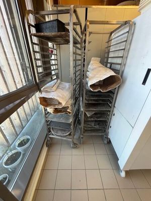 many trays of doughnuts on the shelves in the kitchen
