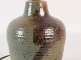 un vase marron et vert sur lequel est posée une lampe