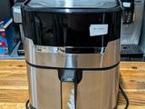 an image of a stainless steel air fryer sitting on a wooden counter