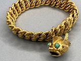 an image of a gold bracelet with a fish charm on it