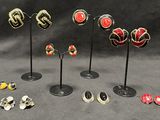 a lot of different earrings on display on a black table