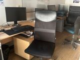 a desk with two computers and a chair in the room
