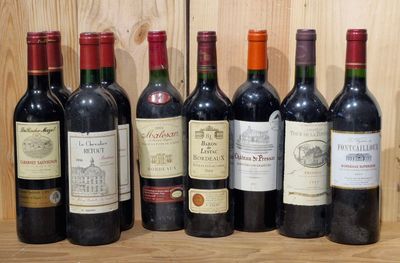 several bottles of wine are lined up on a wooden shelf