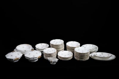 une pile d'assiettes blanches et argentées sur un fond noir