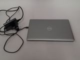 a laptop computer sitting on a table with a charger attached to it