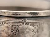 a close up of a silver cup with water droplets on it