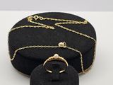 boîte à bijoux en velours noir ornée d'une chaîne dorée et d'une bague