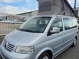 a silver van parked in a parking lot with a tent on top of it