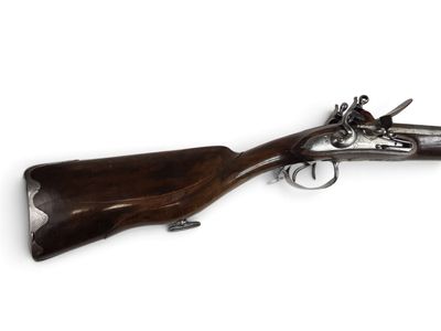 un vieux fusil avec une poignée en bois sur fond blanc