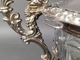 a silver bowl with a handle on a table