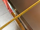 a measuring tape on the side of a stainless steel refrigerator