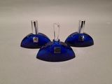 three blue glass candlesticks on a white table