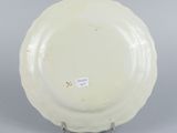 underside view of a white plate on a stand on a gray surface