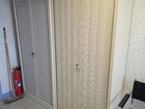 une pièce avec une armoire, une chaise et un seau de peinture