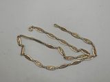 a close up of a gold necklace on a white surface