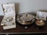 a silver plate with spoons and a bowl on a table