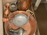 une boîte contenant tout un tas de casseroles et de poêles en cuivre