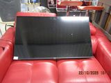 a laptop sitting on top of a red leather couch