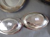 three silver dishes on a table with a silver plate on the table