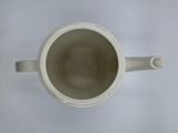 a white cup with a handle on a white table