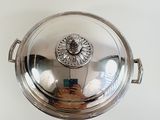 a silver plate with a lid on a white table