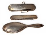 three silver spoons and a spoon rest on a white surface