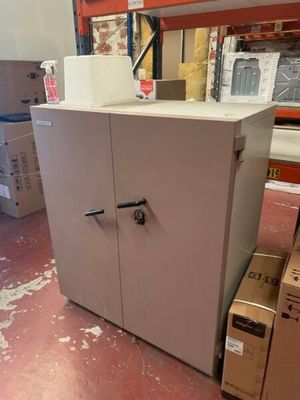 une armoire blanche dans un entrepôt, avec des cartons par terre
