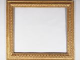 un cadre photo doré sur un mur blanc avec un fond blanc