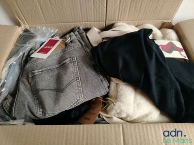 une boîte en carton remplie de vêtements et d'un jean