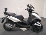 a picture of a white and black scooter parked on a checkered floor